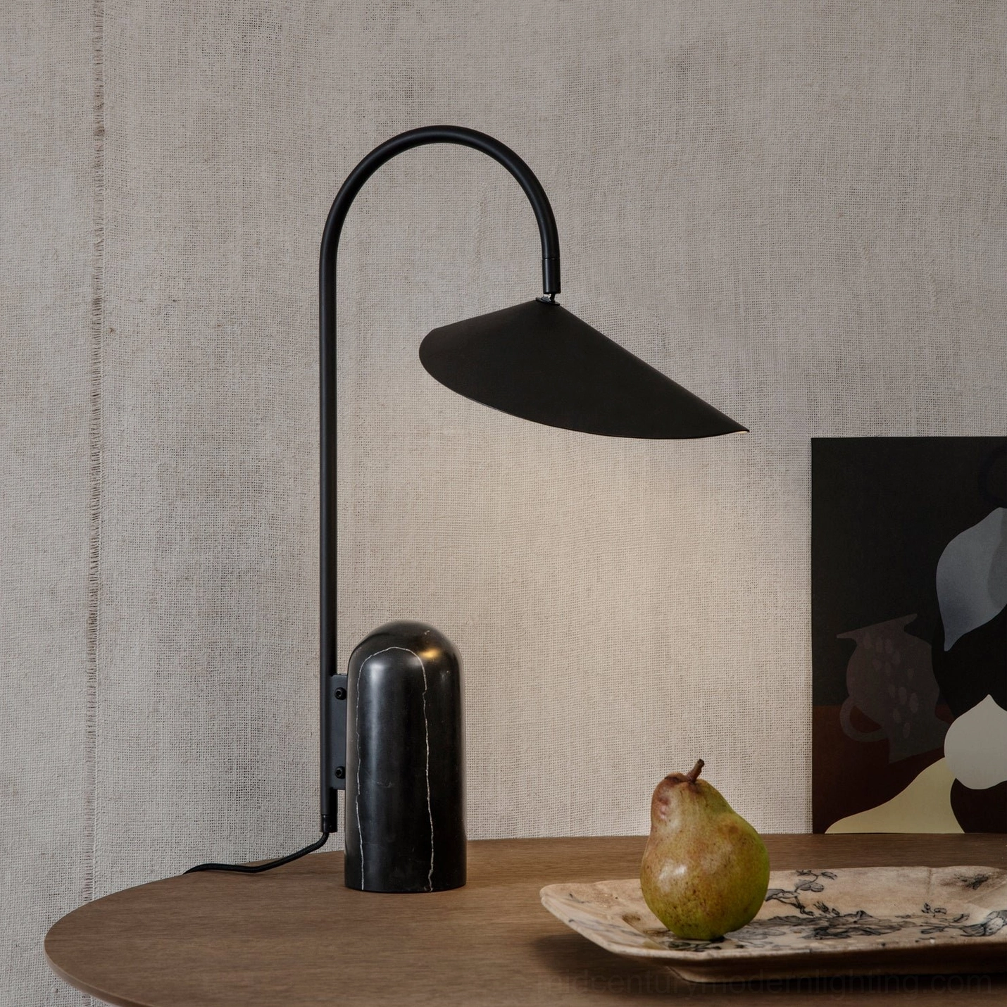 Minimalist black Mono lamp with natural stone base on floating shelf with modern decor