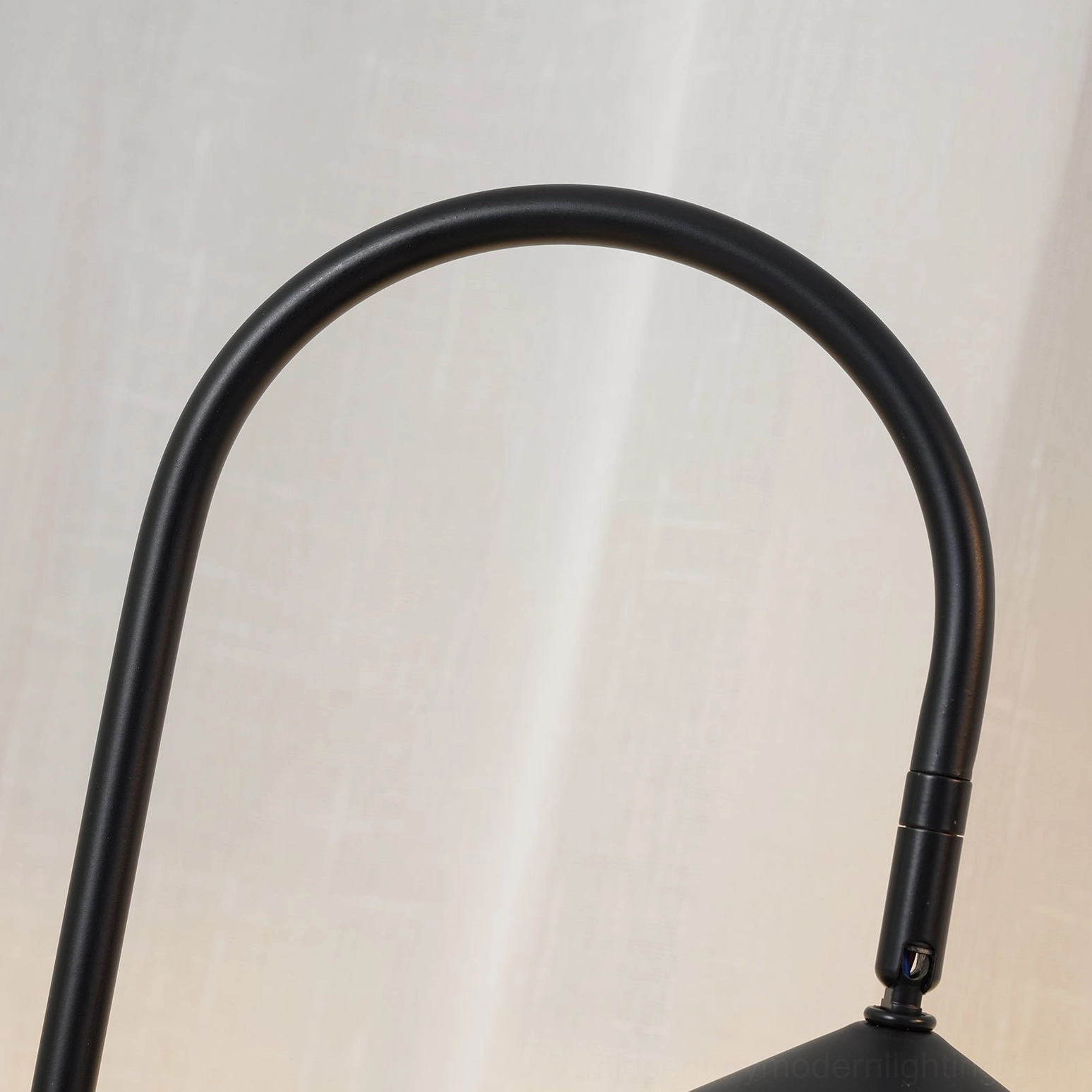 Black arc table lamp with minimalist conical shade and natural cavestone marble base