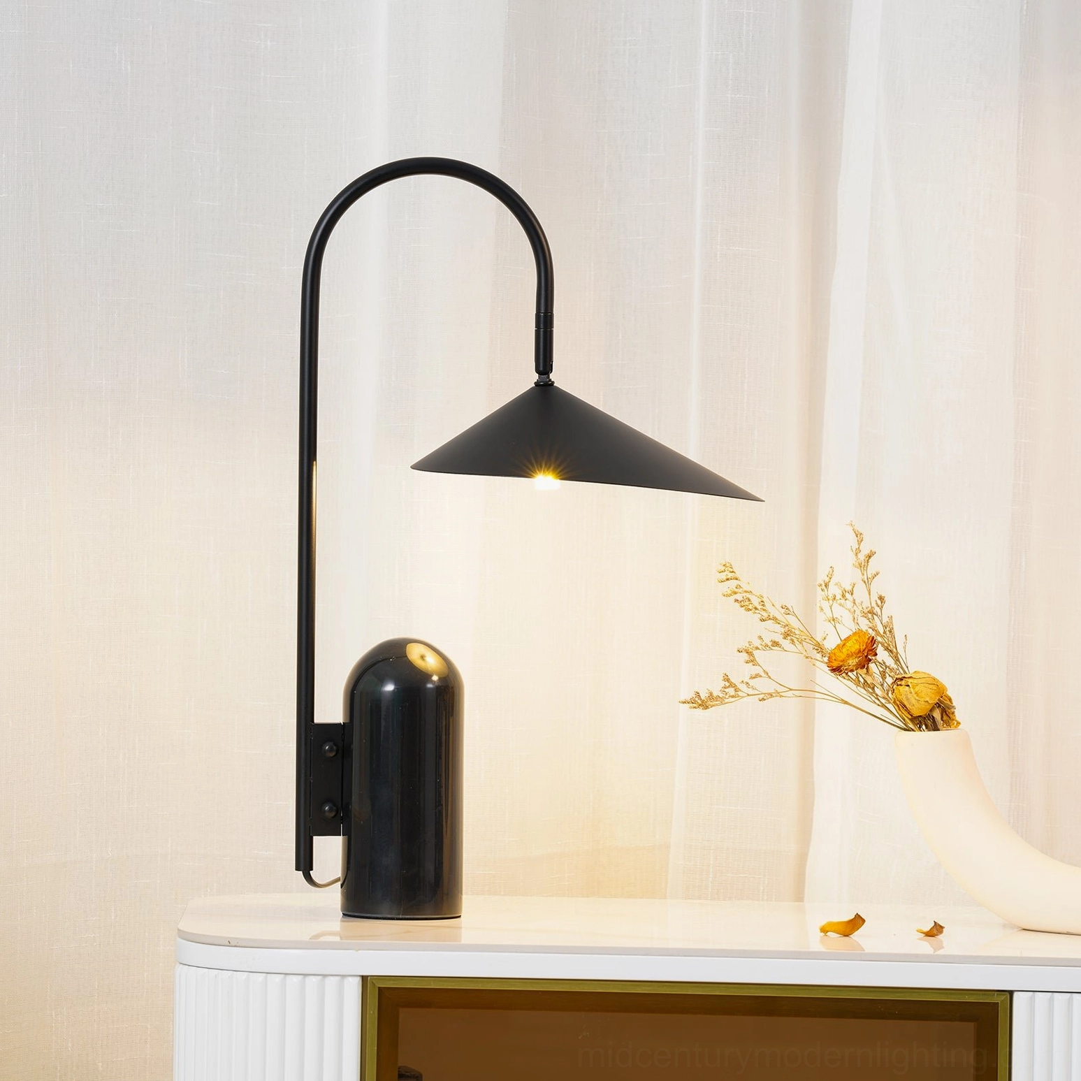 Minimalist black arc lamp with conical shade and natural stone base in modern interior design