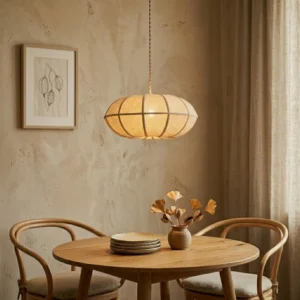 Montecito pendant light suspended above warm dining table in cozy wabi-sabi interior, soft warm ambient lighting through ribbed linen shade