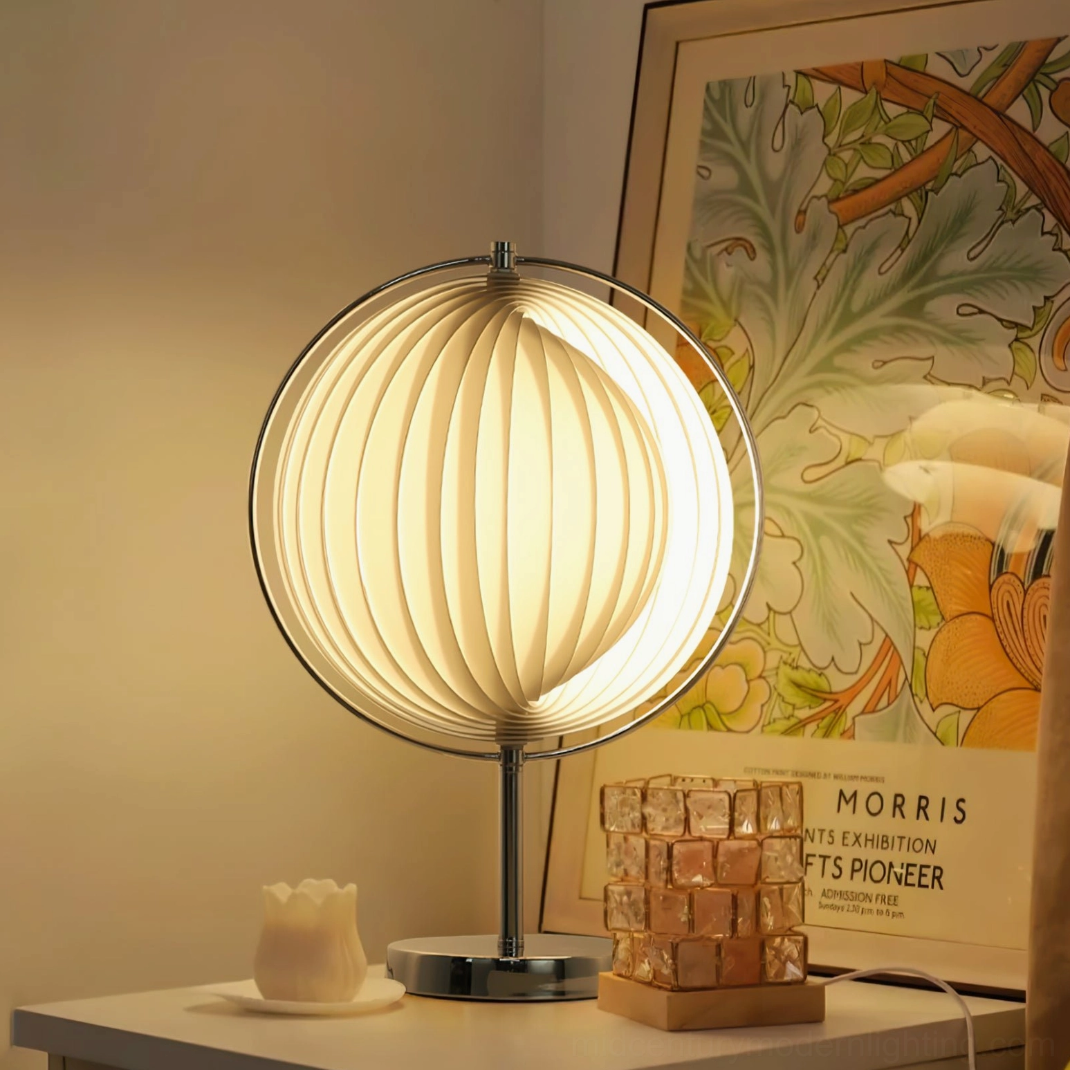 Moon Kare table lamp with warm light on modern indoor side table, decorative candle and crystal block display