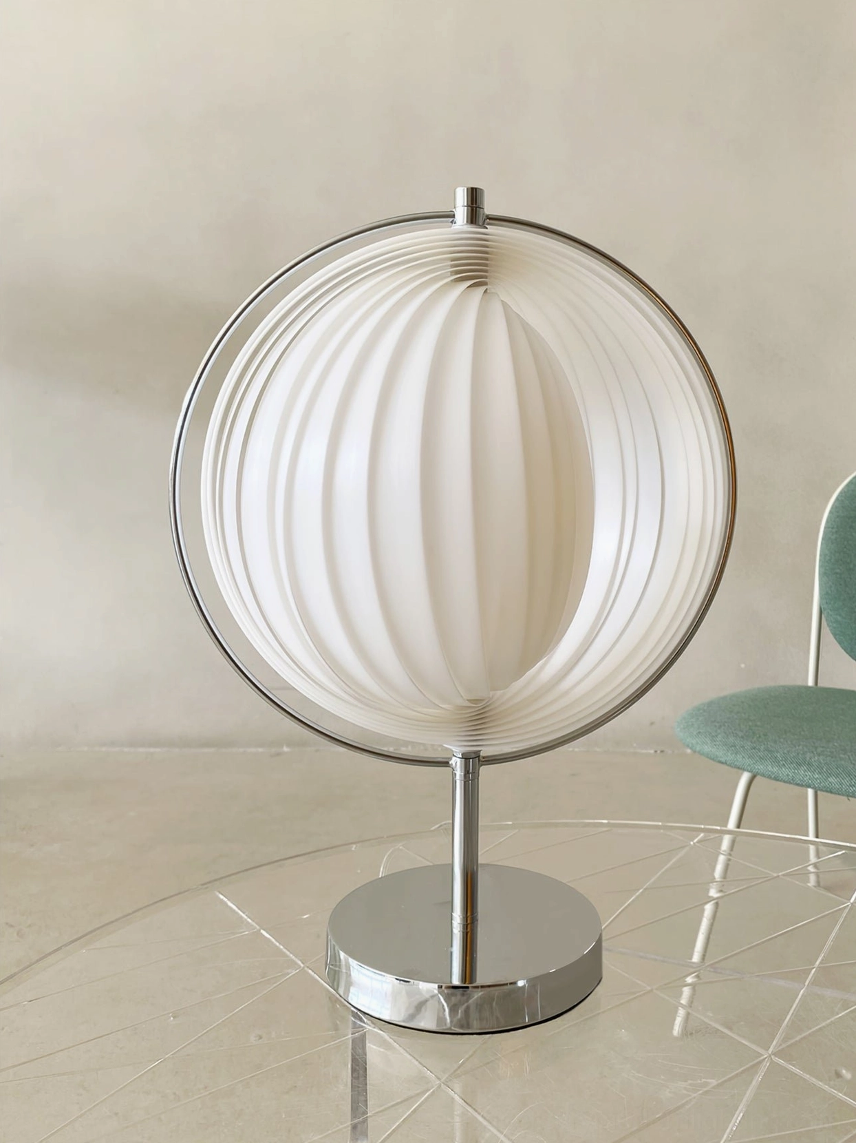 Moon Kare table lamp with chrome base and white ribbed shade on modern dining table with teal chair