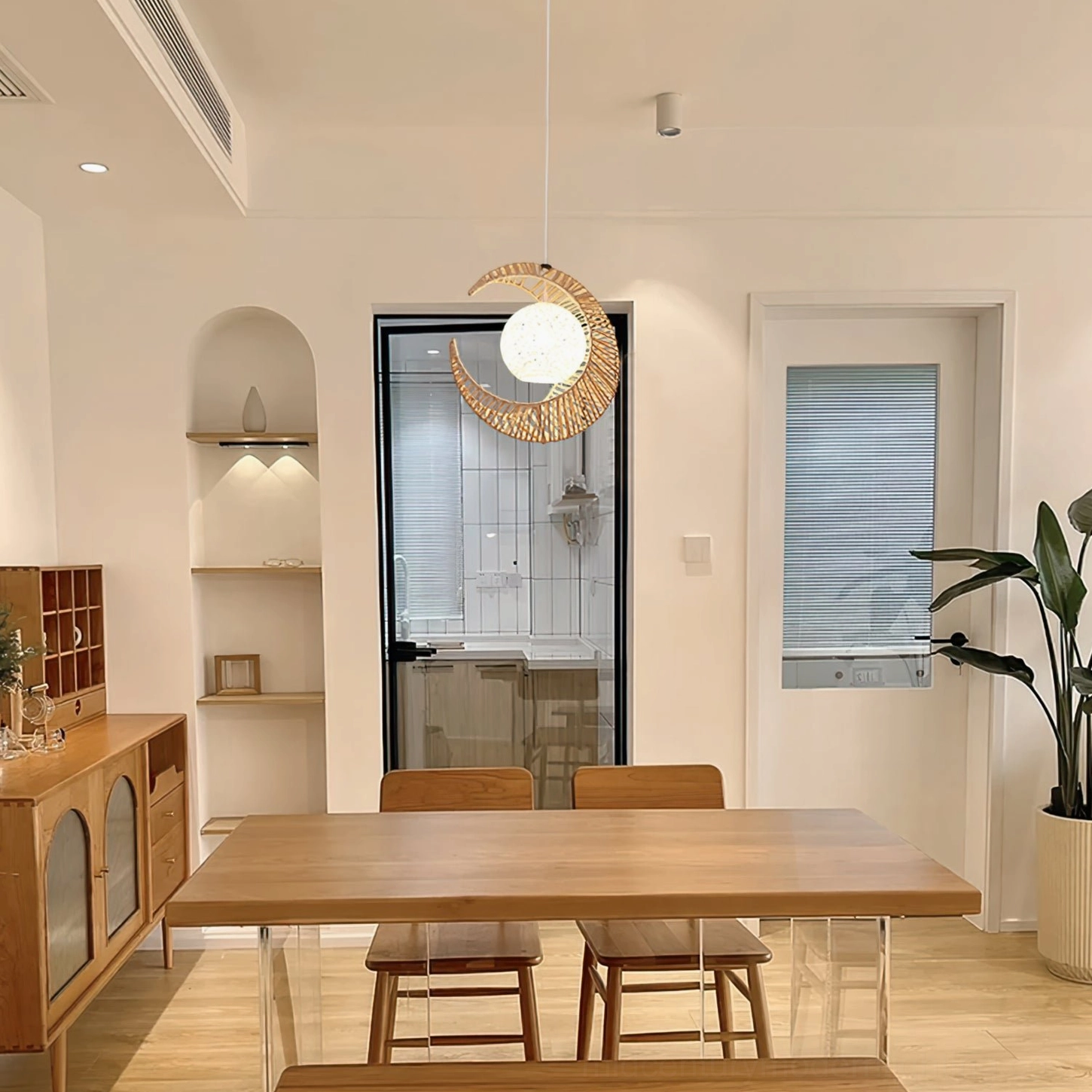 Natural hemp rope moon pendant light in warm minimalist dining room with wooden furniture and modern decor