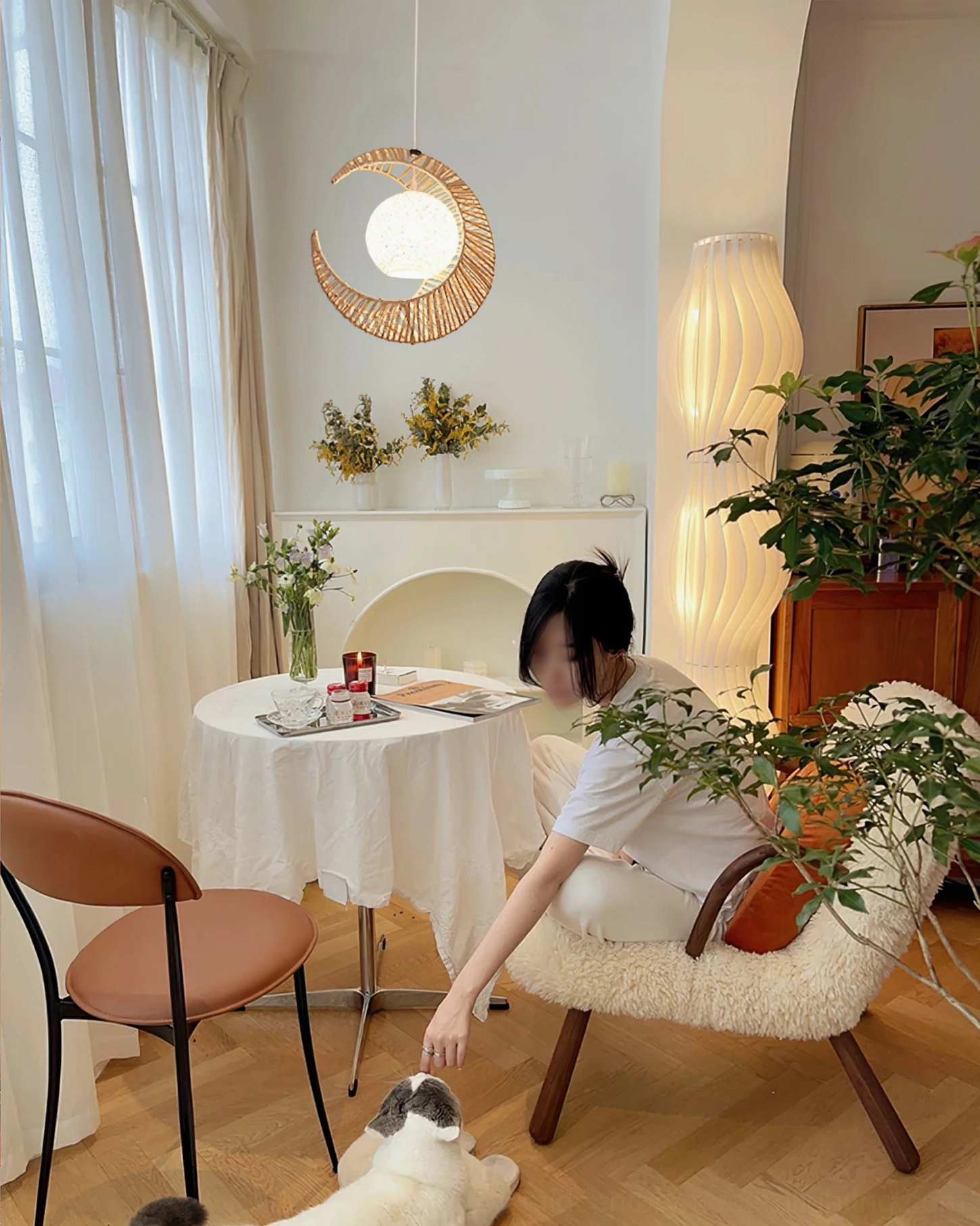 Modern open-plan kitchen dining area illuminated by natural minimalist crescent moon pendant light with soft glow