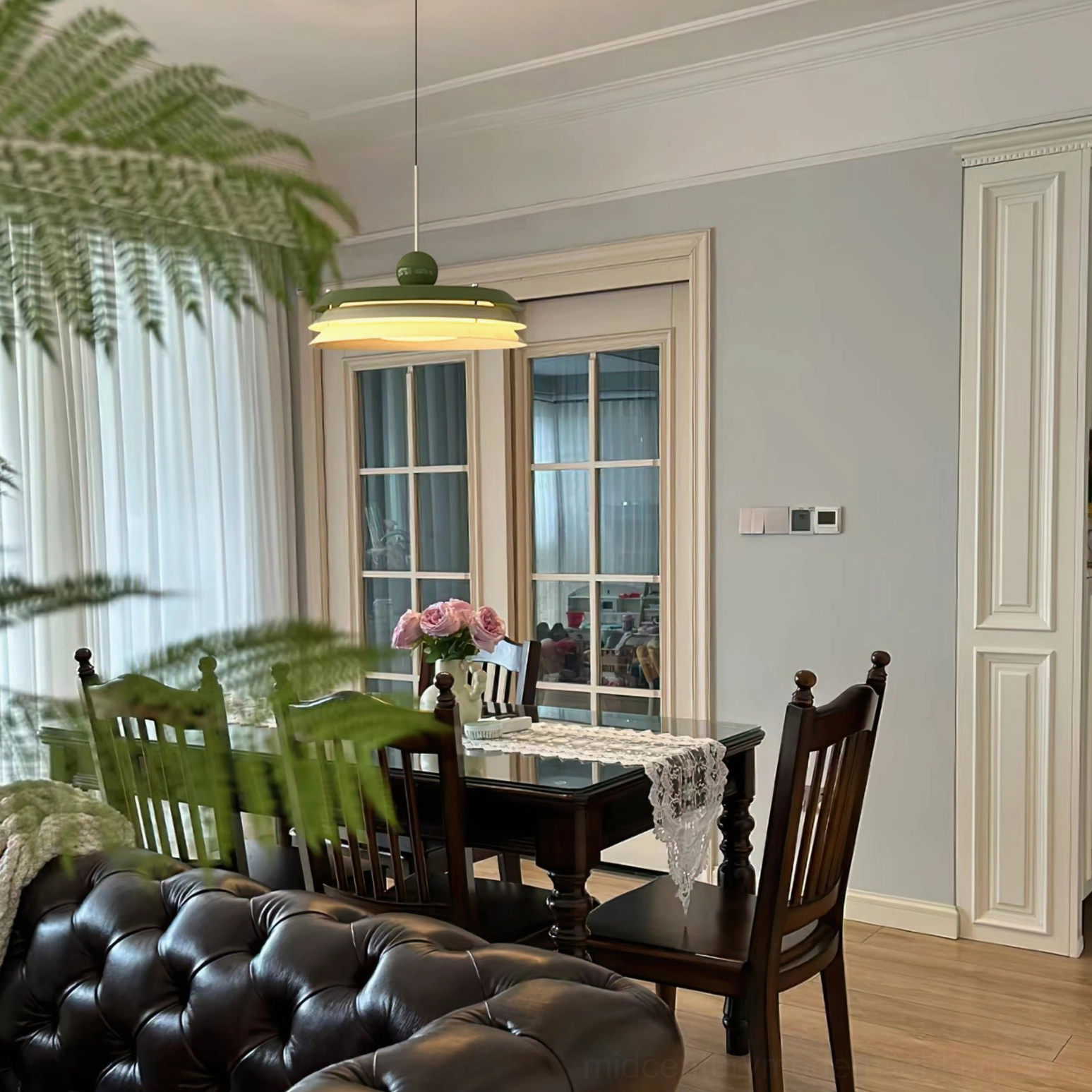 Muted green Morandi pendant light in traditional formal dining room with dark wood furniture