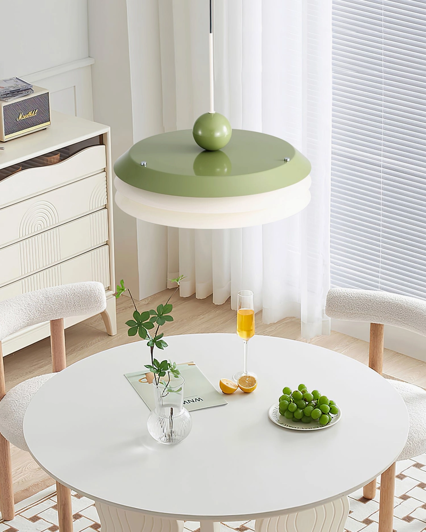 Green and white layered pendant light fixture in Scandinavian dining nook with neutral décor