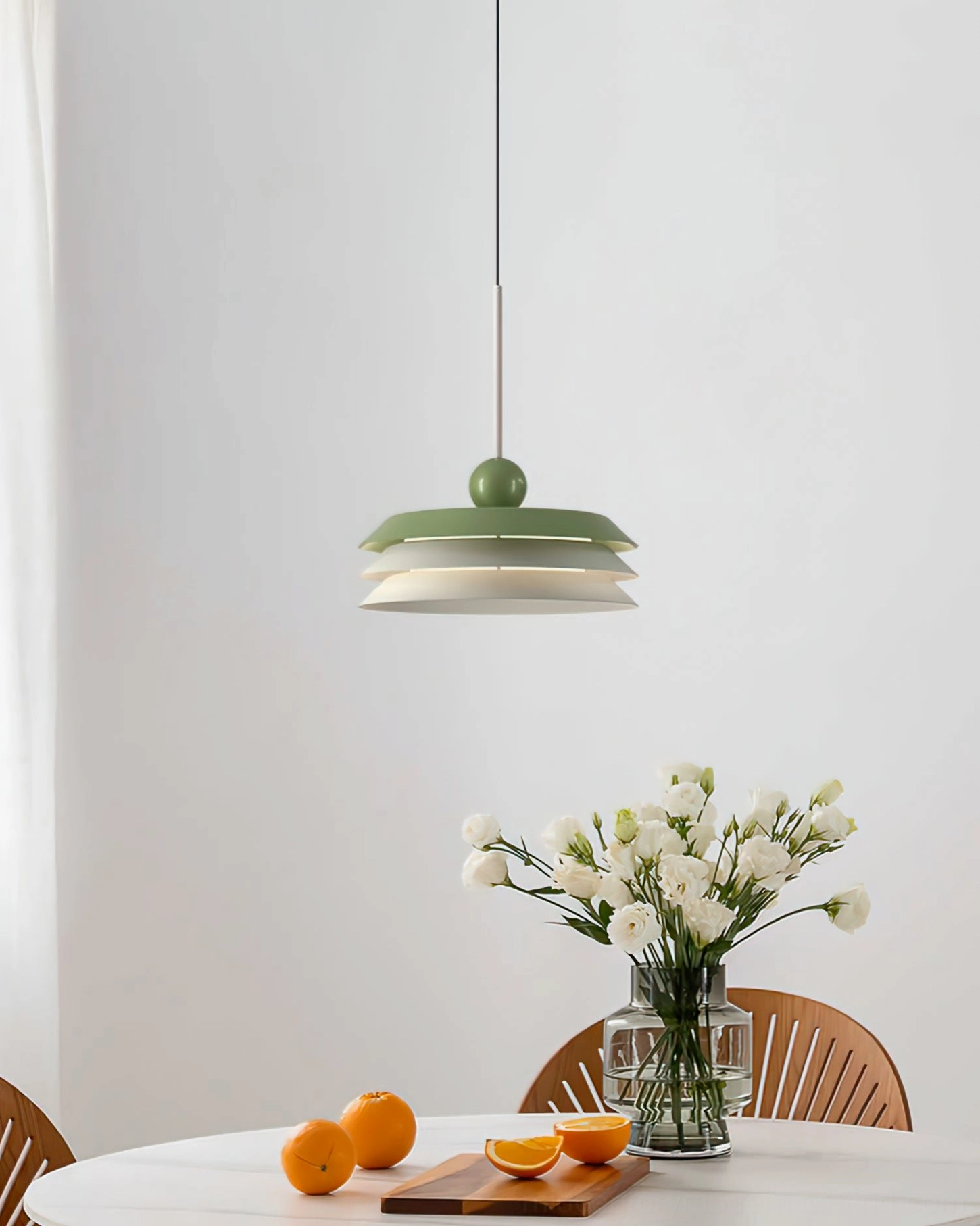 Morandi layered pendant lamp casting warm light above minimalist dining table with wood accents