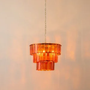 Moreland pendant light hanging with warm amber glow and brass metal suspension chain