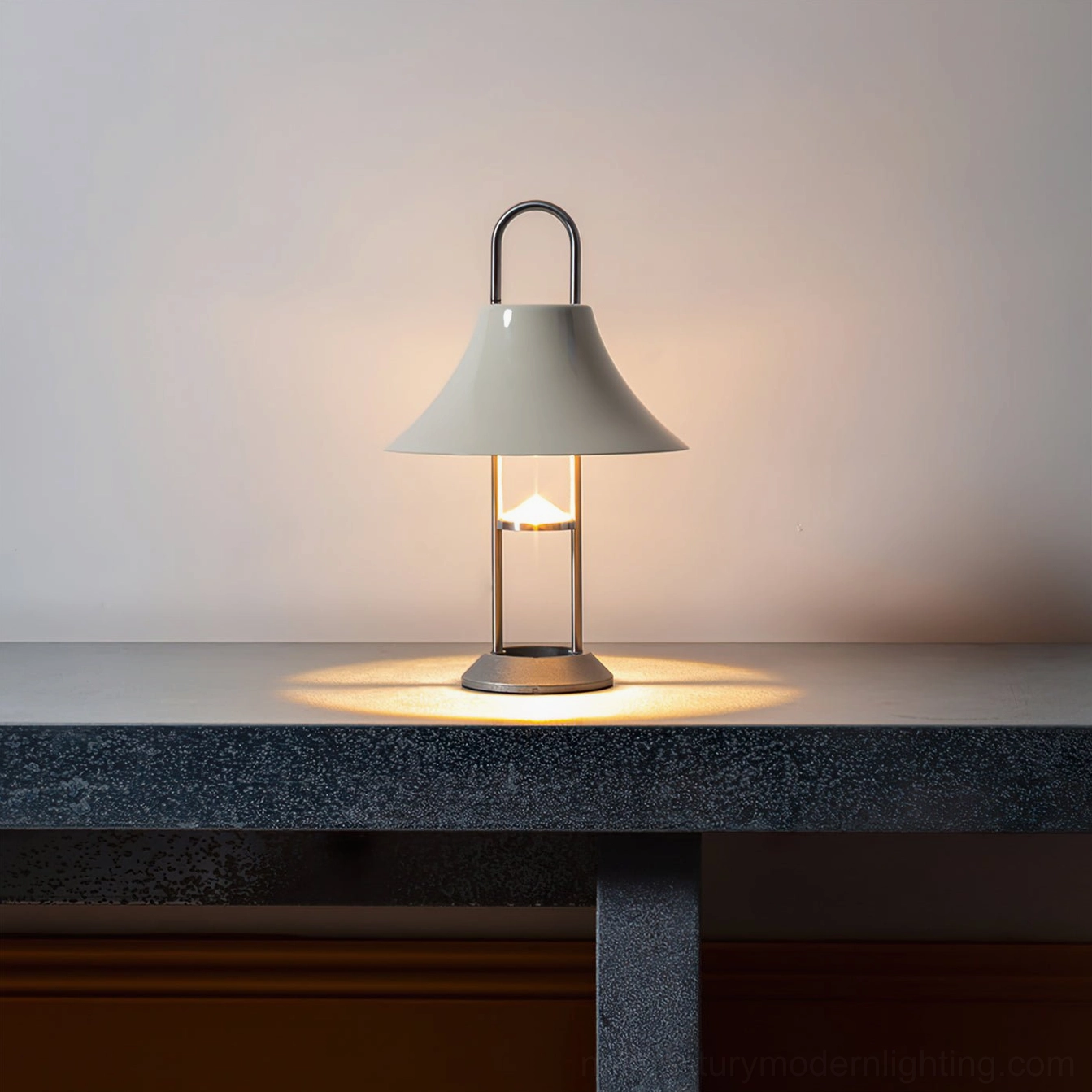 Illuminated Mousqueton portable table lamp emitting warm light with light gray conical shade in modern interior setting