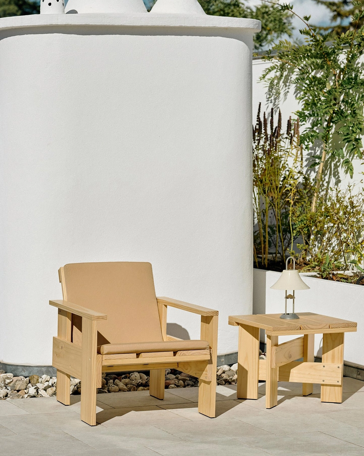 Oyster white modern portable battery lamp on small white side table in minimalist outdoor patio setting