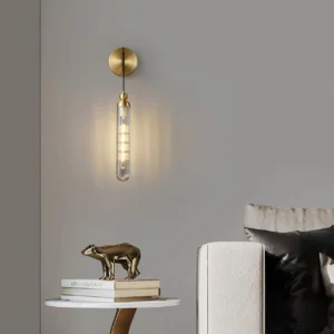 Brushed brass Mullan wall sconce in modern living room, cylindrical glass pendant design illuminated