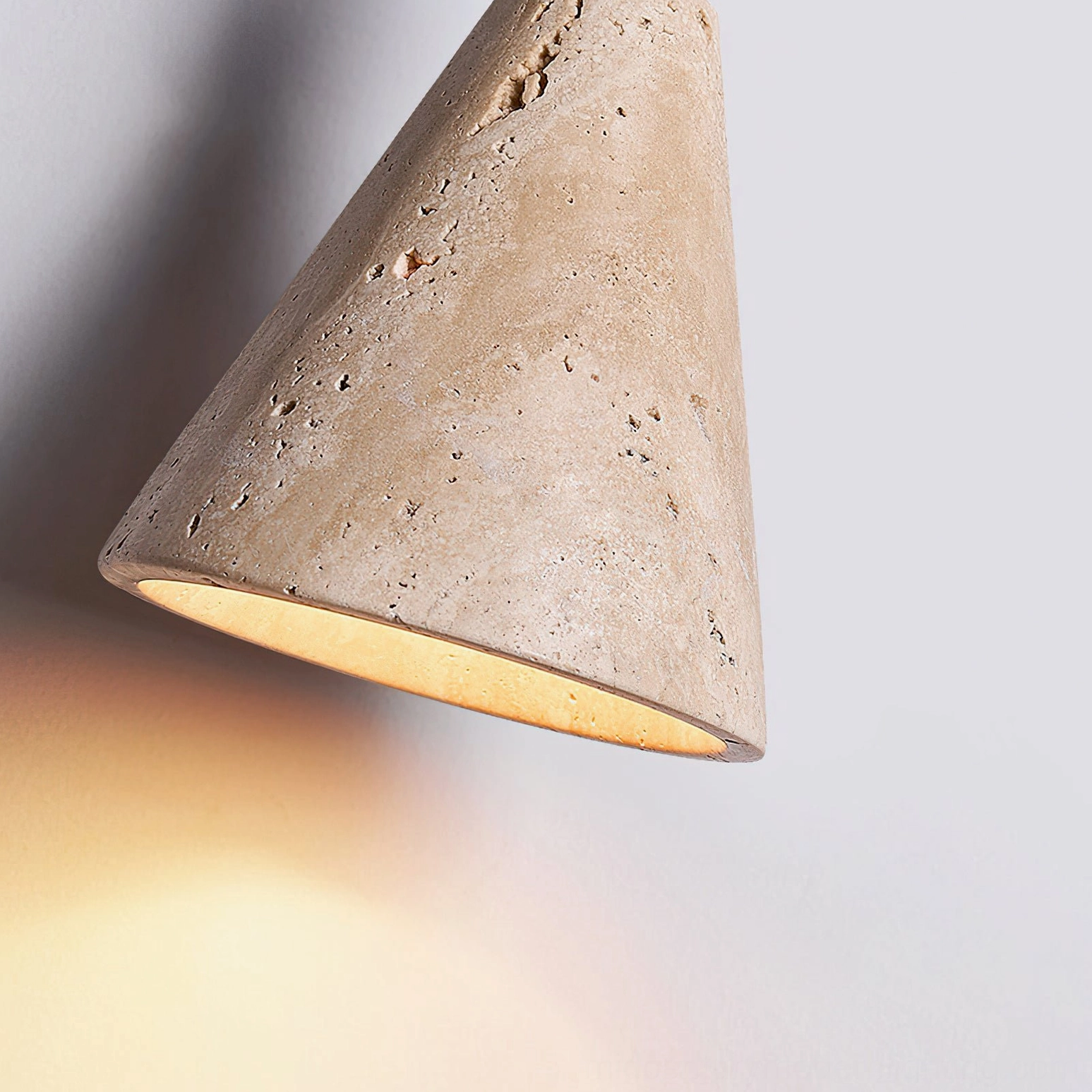 Multiple Canyon travertine pendants hung at varying heights creating sculptural modern lighting installation