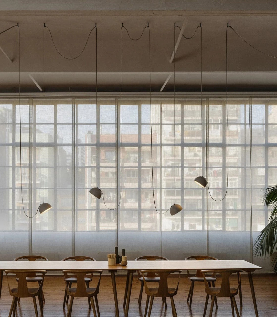 Matching leather sling pendant lamps in modern study lounge creating ambient lighting over workspace