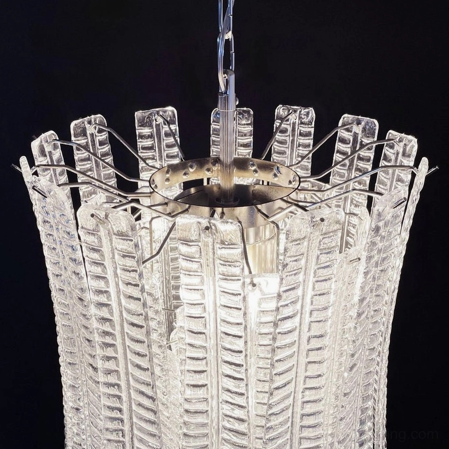 Close-up detail of Murano glass chandelier base showing exposed chrome metal support frame and ribbed textured leaf glass shades