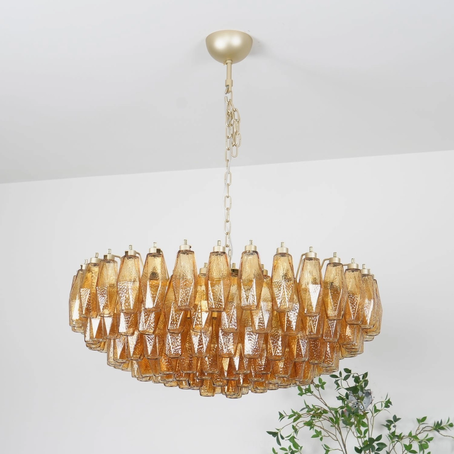 Geometric amber Murano glass chandelier in modern minimalist white interior showing ridged glass form and warm light