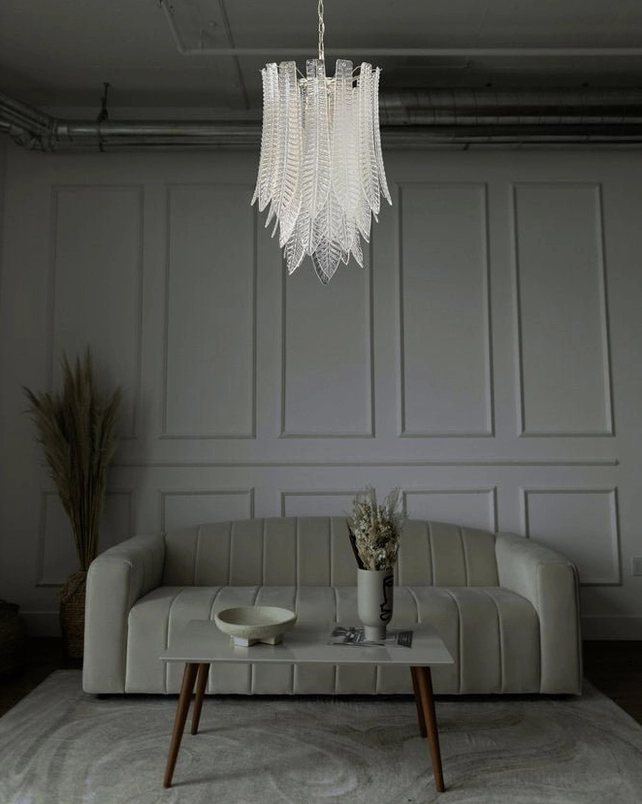 Murano glass feather chandelier installed in modern minimalist living room with wainscot wall, demonstrating contemporary interior styling