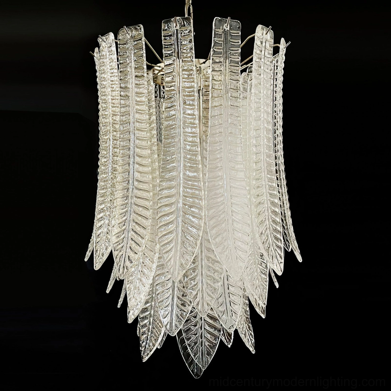 Side close-up of Murano glass feather chandelier showing vertical stacked leaf glass elements and polished chrome metal support frame
