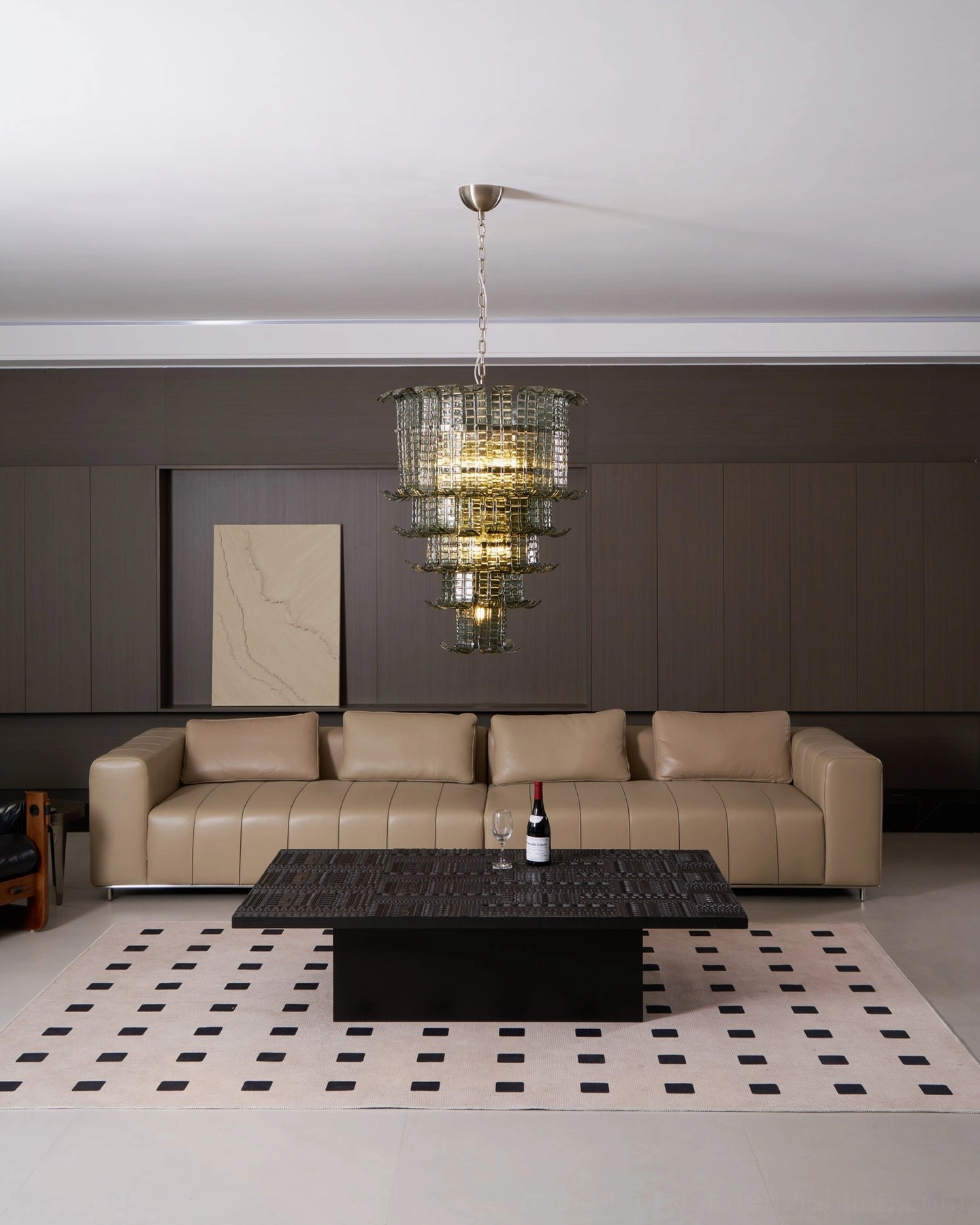 Unlit murano smoked green tiered glass chandelier in contemporary living room with checkered area rug, modern furniture arrangement