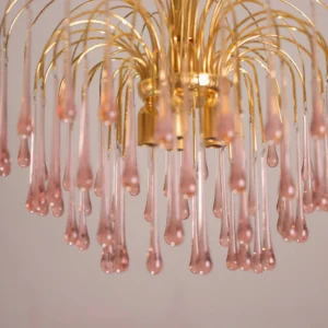 Close-up detail of hand-blown Murano pink glass droplets and polished gold metal arms of the fireworks chandelier
