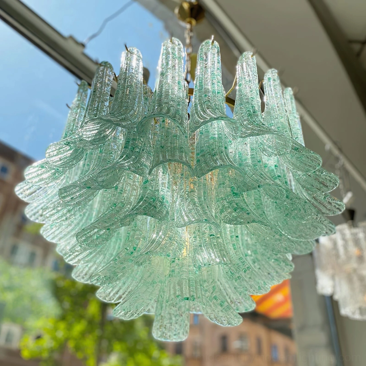 Close-up overhead side view of Murano green chandelier showcasing layered ruffled glass shades and mint-green tinted glittery glass panels