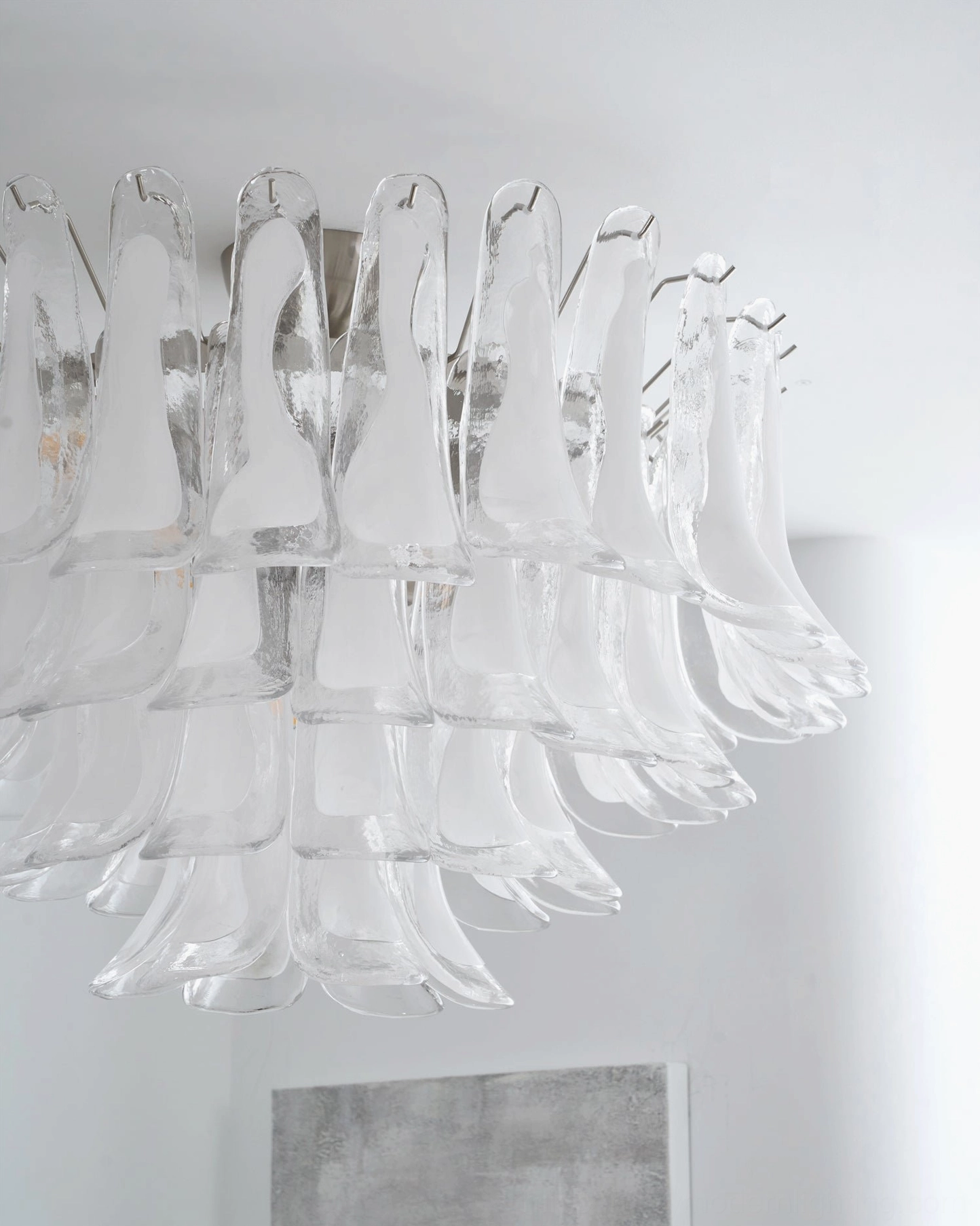 Close-up of Murano Petal fixture showing polished metal hardware, curved hand-blown glass petals and light refraction