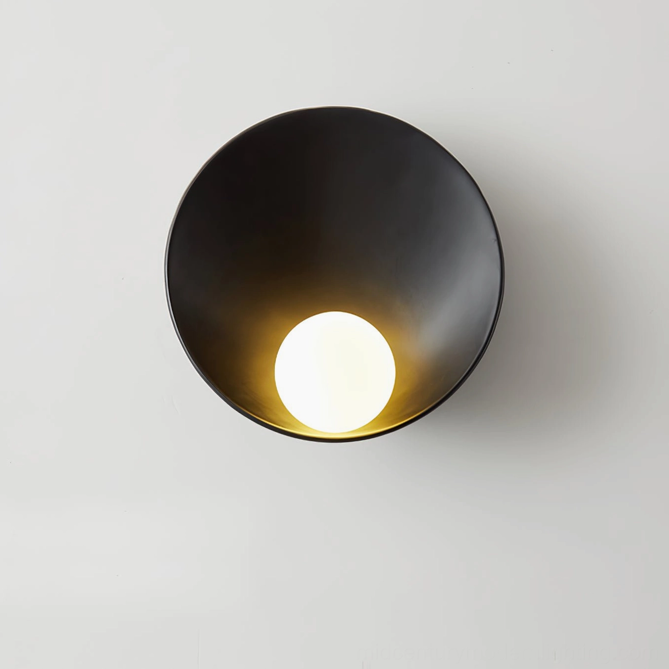 Black Musa wall lamp showing angled perspective with warm glowing bulb and conical matte metal shade