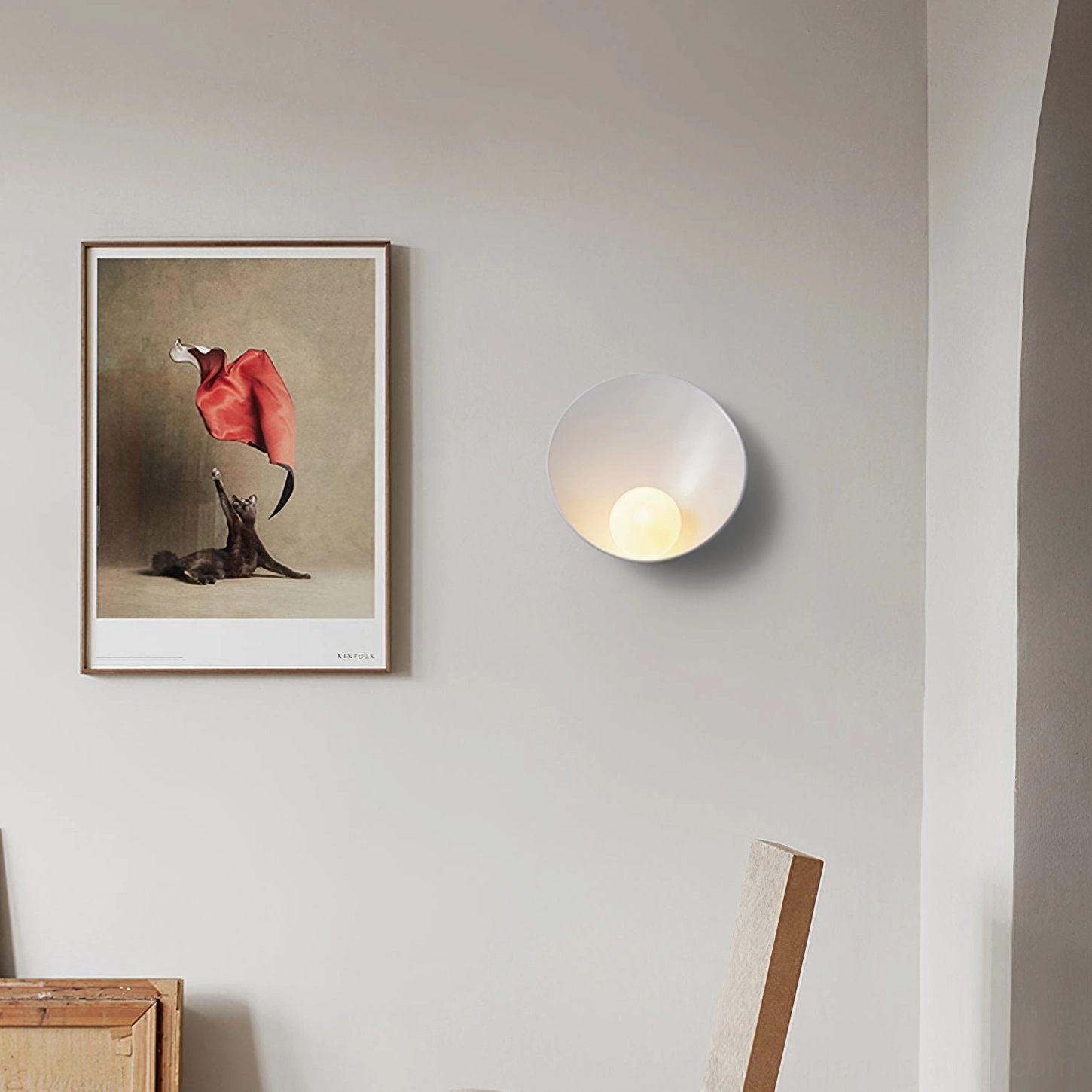 White Musa wall sconce on minimalist hallway wall with artwork, soft warm ambient light