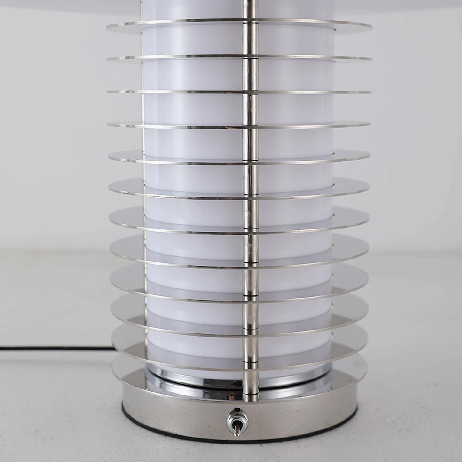 Close-up detail of mushroom table lamp layered chrome grille and metal base construction