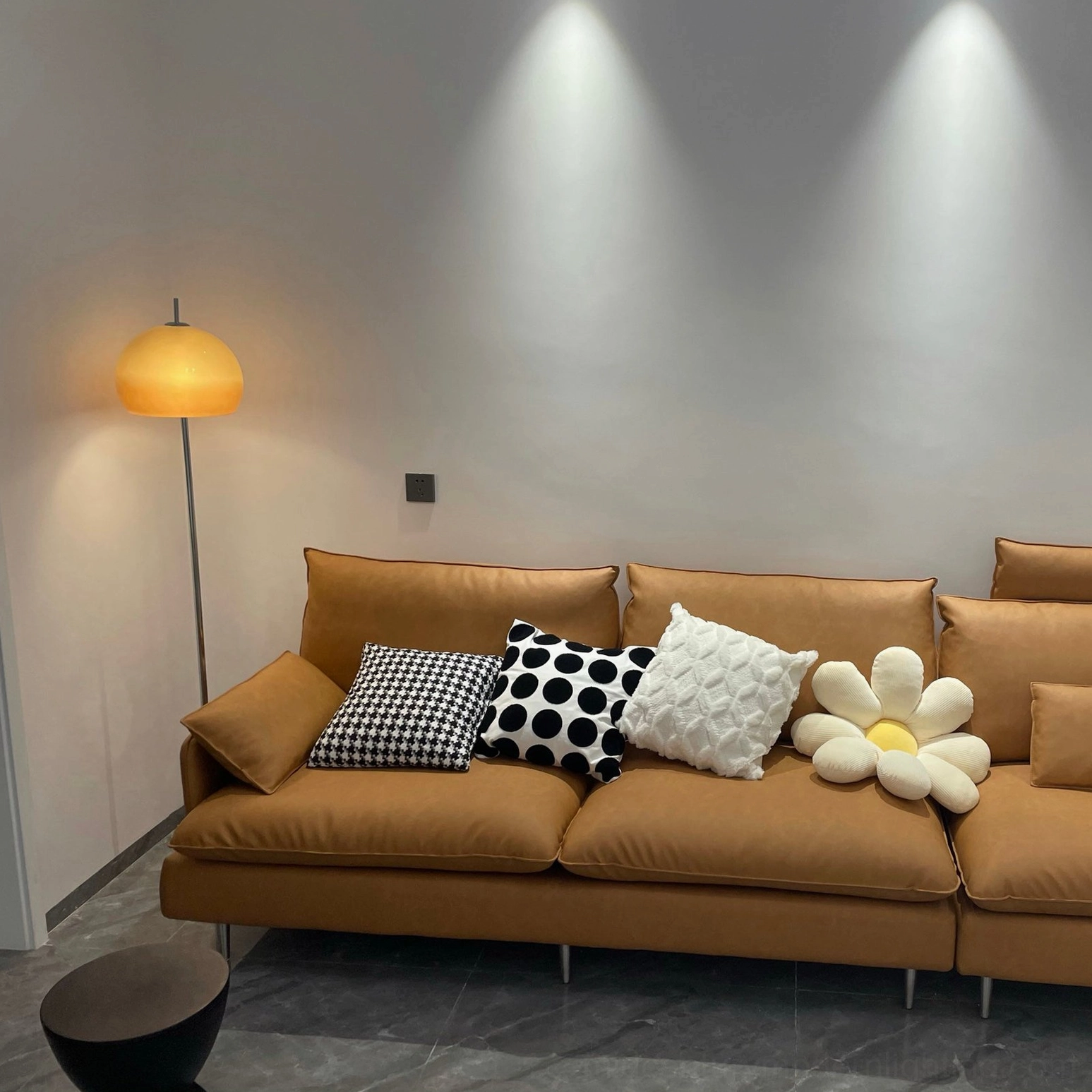 Mushroom floor lamp casting soft warm glow beside brown sofa lounge with decorative pillows