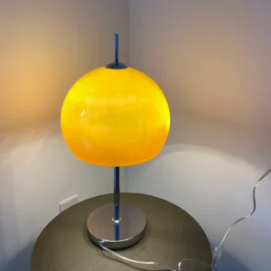 Mid-century modern mushroom lamp with warm glowing amber shade in contemporary living room corner setting