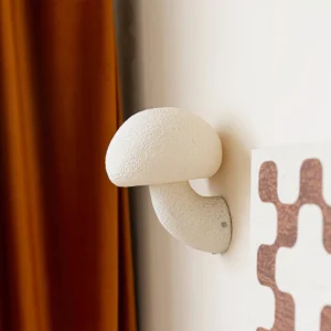 Mushroom resin wall lamp installed on residential wall with brown velvet curtain - warm interior ambient lighting