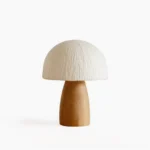 Mushroom table lamp with textured paper shade and light brown wooden base, studio shot on white background