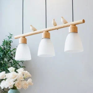 Muto Bird Chandelier side close-up detail - showing three matte white bird ornaments and warm lighting effect