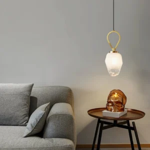 Gold Myla pendant lamp installed in modern minimalist living room with warm luxury aesthetic and contemporary furnishings