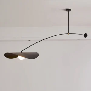 Black Myrna ceiling pendant with long articulating arm and sliding counterweight mechanism, overhead studio perspective