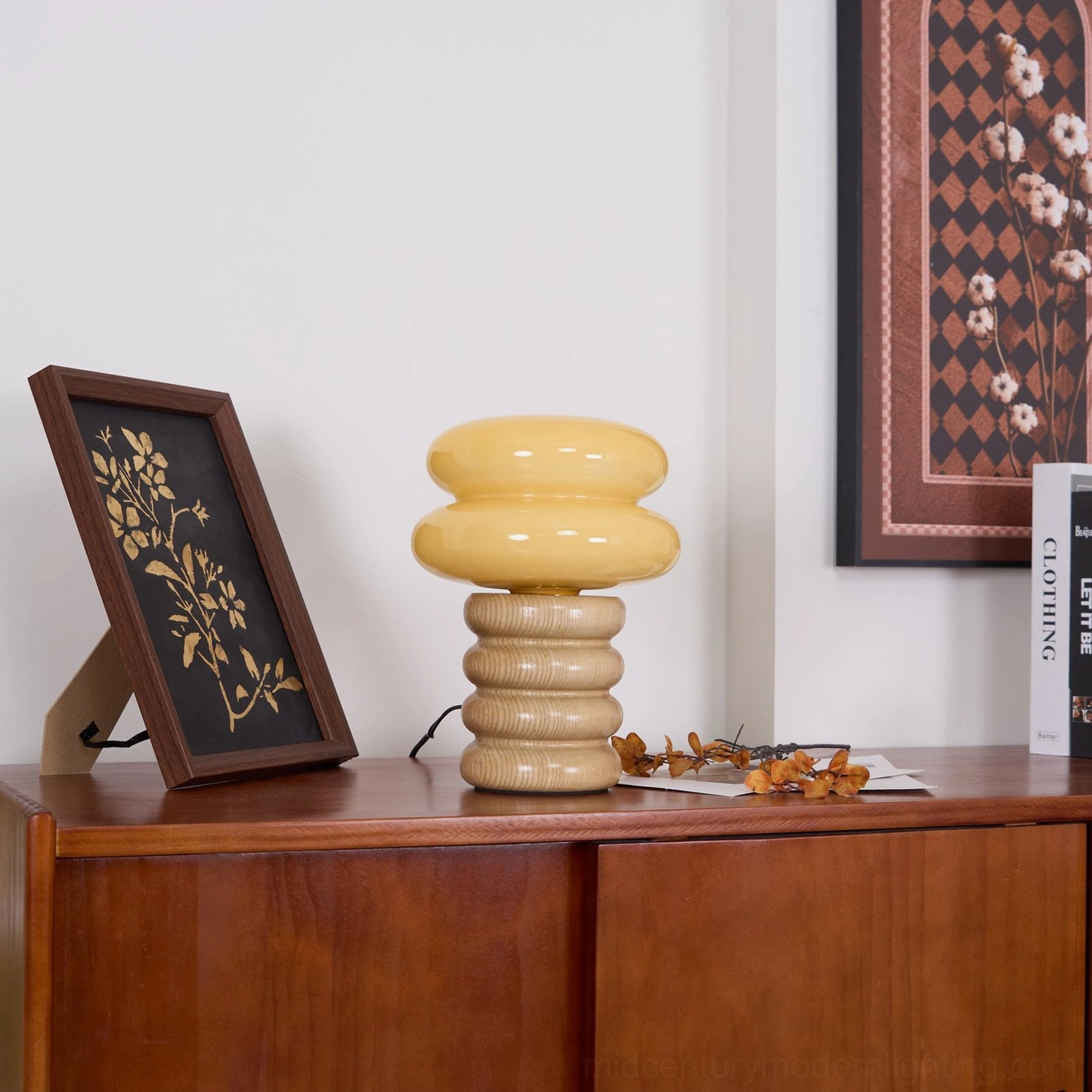 Right-side three-quarter profile of slim Napako minimalist table lamp with wooden base on console table with books
