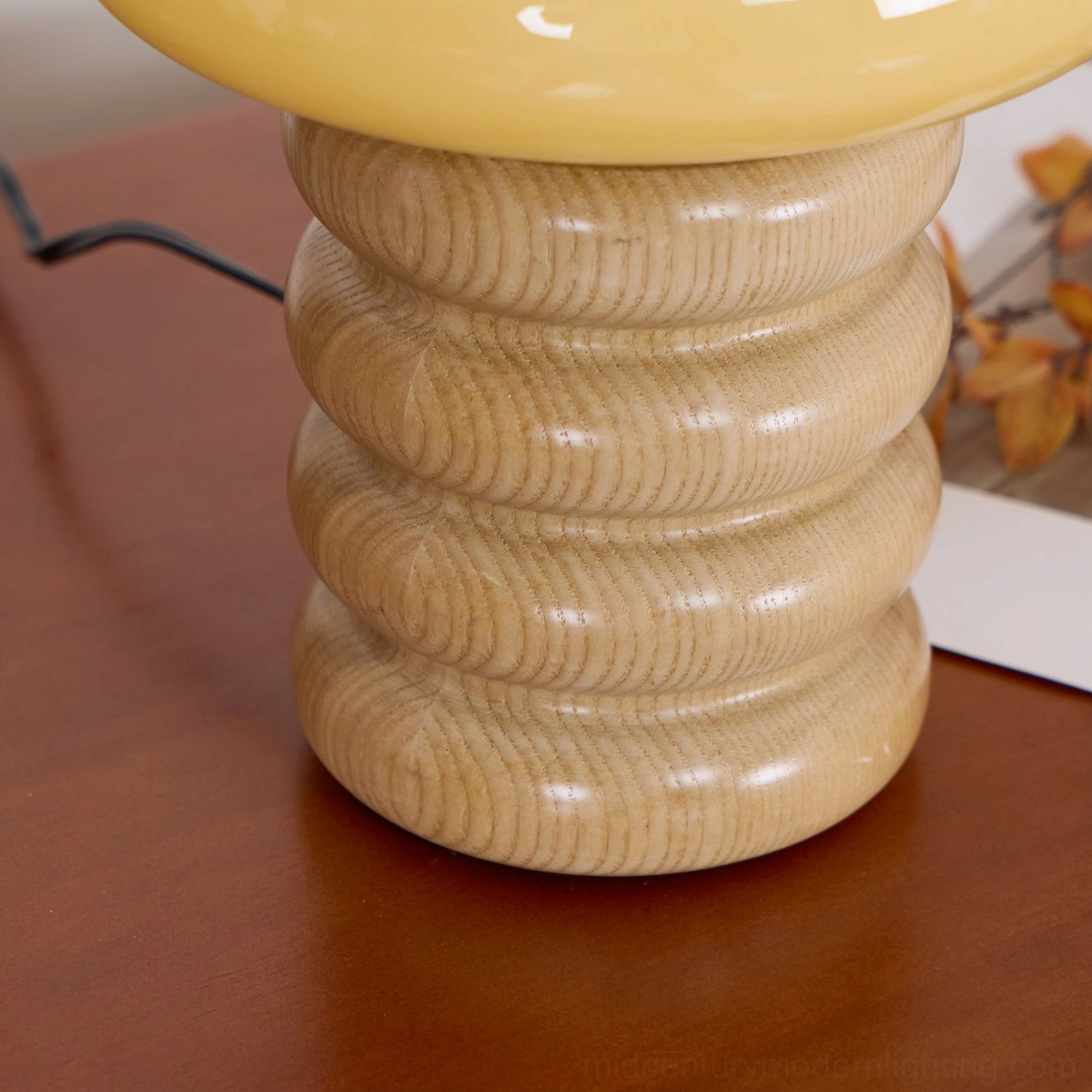 Close-up detail of Napako lamp base showing ringed ash wood grain texture and hand-spliced craftsmanship on polished surface
