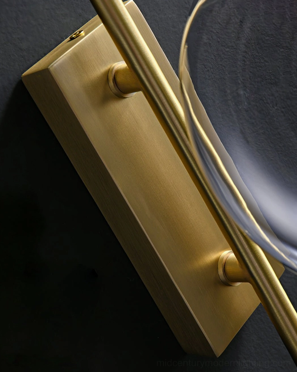 Contemporary glass globe wall light fixture with minimalist metal construction and warm finish