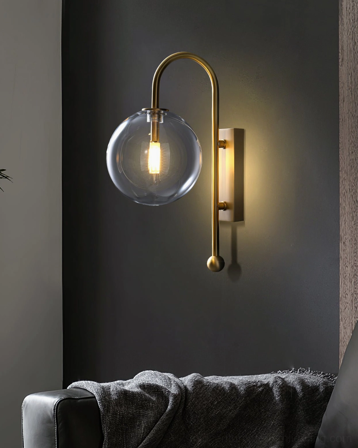 Contemporary glass globe wall lamp paired with sofa in modern living room with dark accent wall