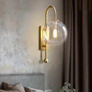 Copper glass globe wall lamp mounted on grey bedroom wall beside bed creating warm bedside lighting