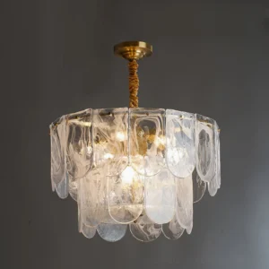 Close-up detail of Nason brass chandelier ripple glass shade with twisted brass rod, warm ambient lighting against gray wall