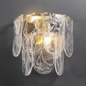 Close-up detail of Nason brass wall sconce showing textured flowing glass shade with warm gold hardware interior finish