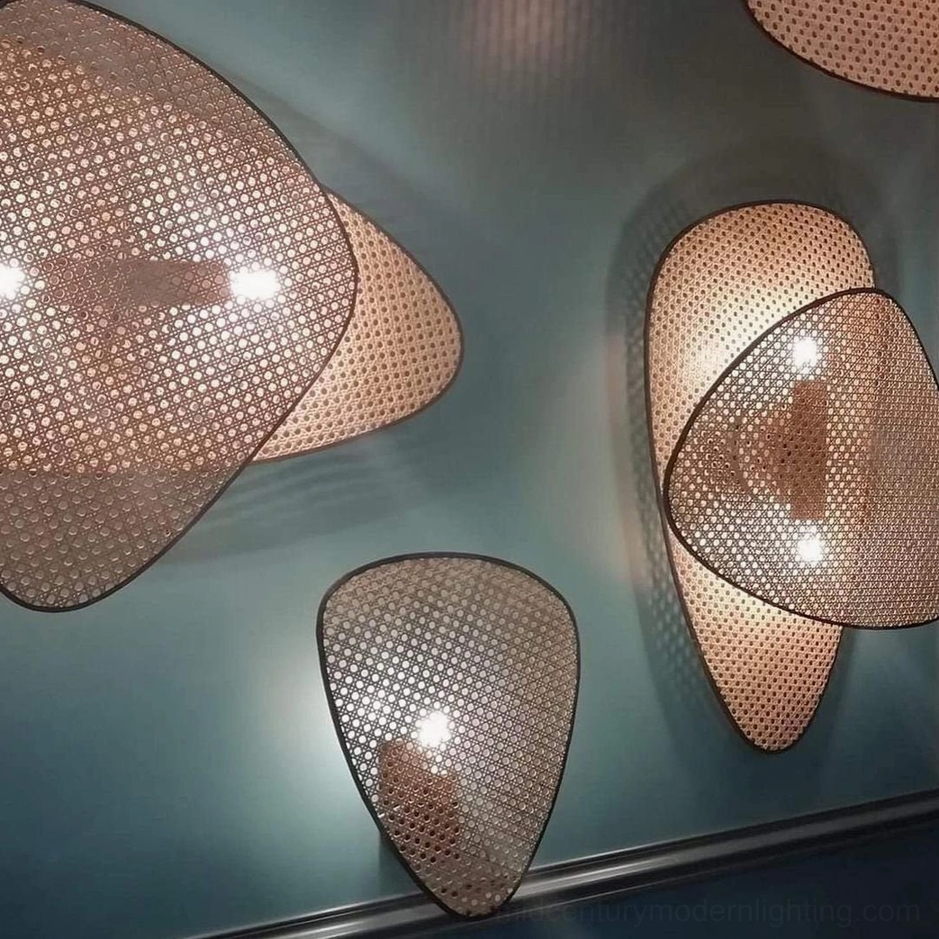 Natural bamboo rattan wall lamp mounted on accent wall showing black metal frame and geometric weave pattern