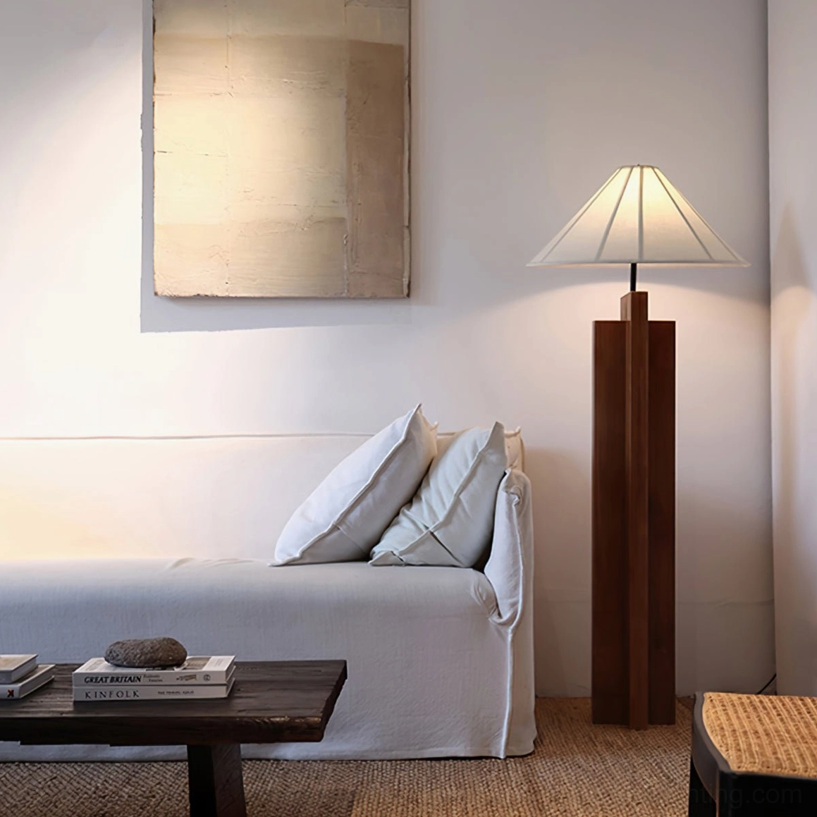 Natural wood tone floor lamp with white fabric shade and black metal accents on studio white background