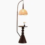 Naumy arc floor lamp with integrated wooden side table, front studio view showing dark brown metal frame and pleated beige fabric shade