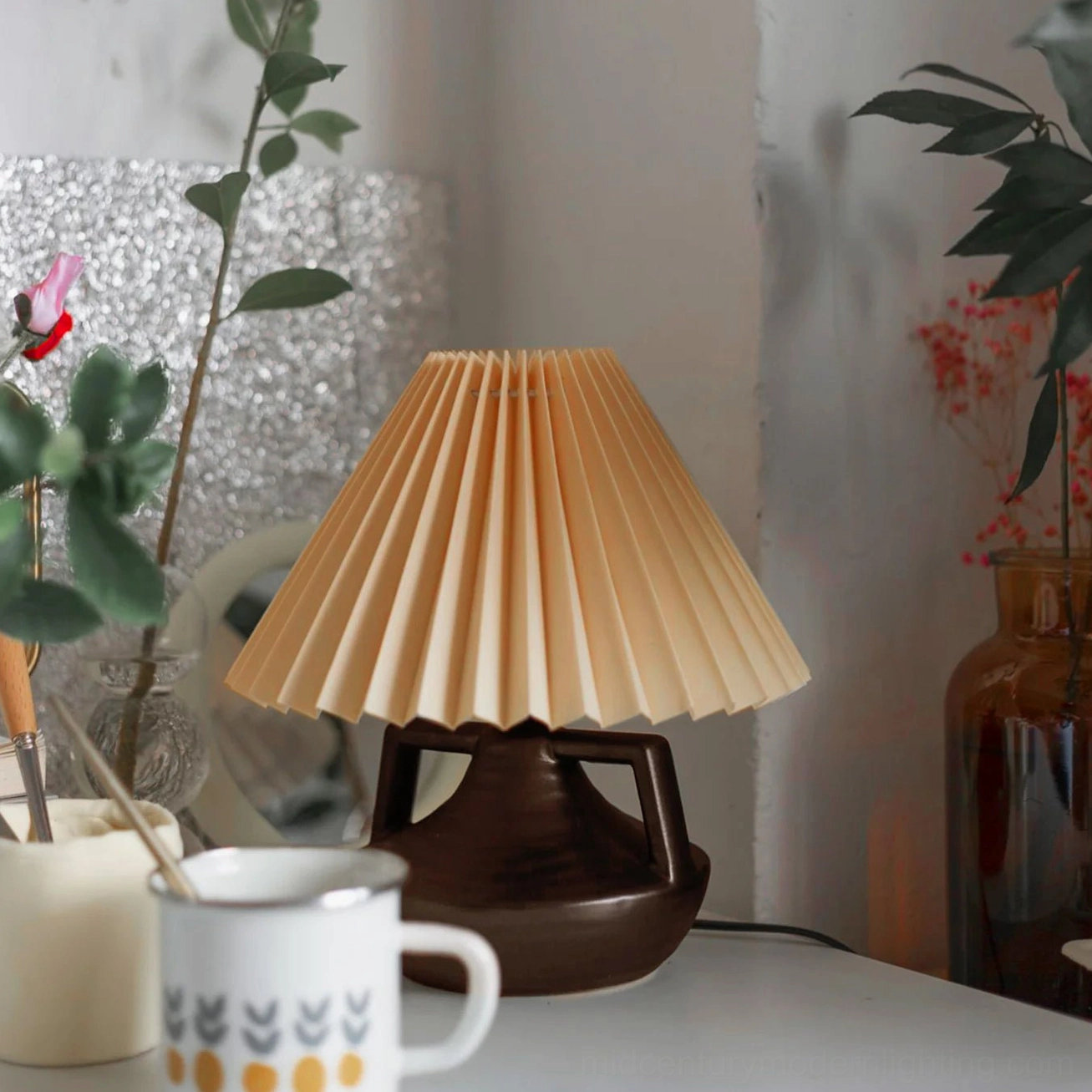 Navia pleated lamp on table with mugs and potted plants, fresh bohemian home aesthetic