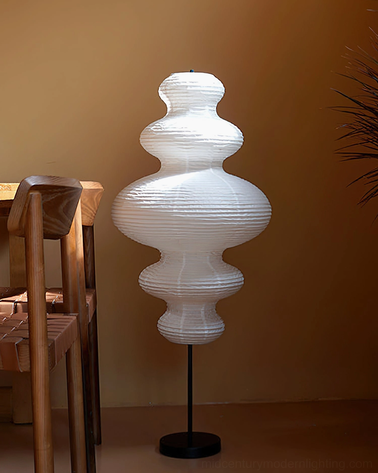 Three-quarter side view of Neiko floor lamp in wooden dining corner, warm earthy wabi-sabi aesthetic