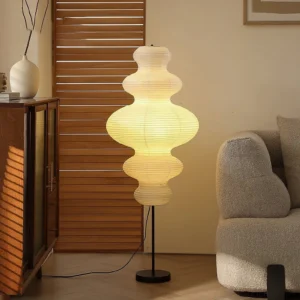 Lit Neiko paper floor lamp casting warm yellow glow in vintage mid-century modern living room with louver wall