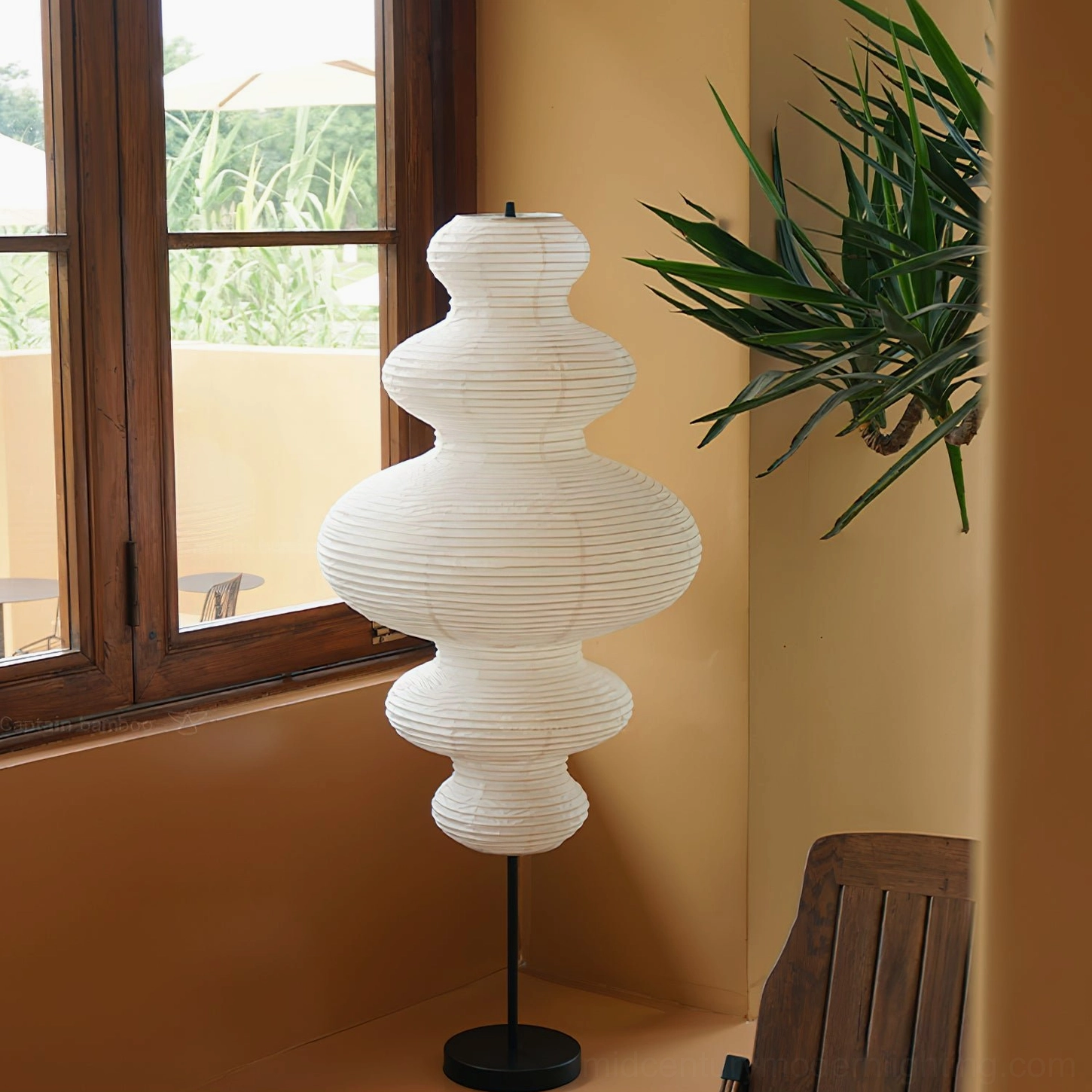 Unlit Neiko washi paper floor lamp side view in sunlit corner with potted green plant decor