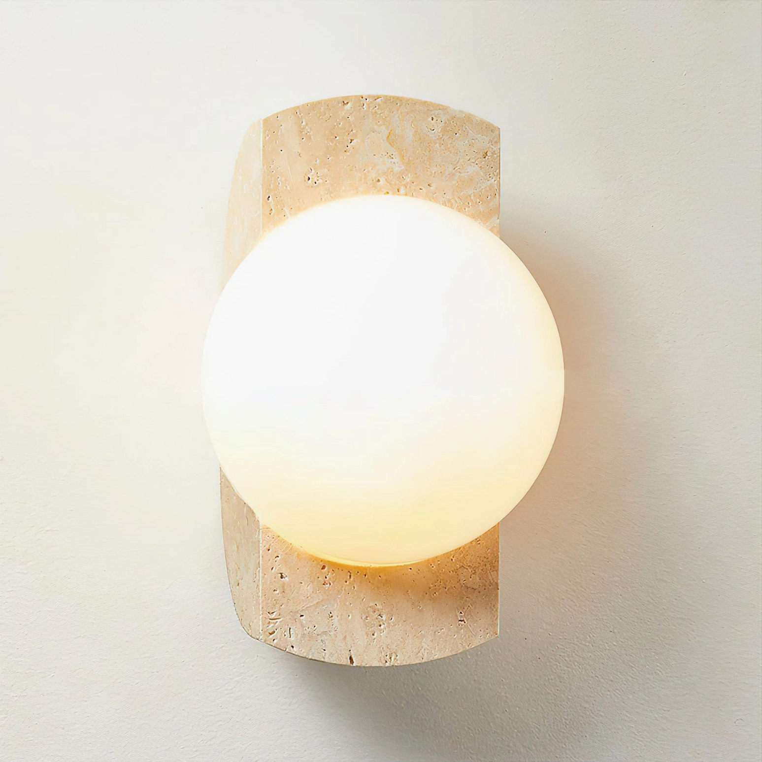 Neptune beige travertine sconce illuminated with warm white glass - studio lighting